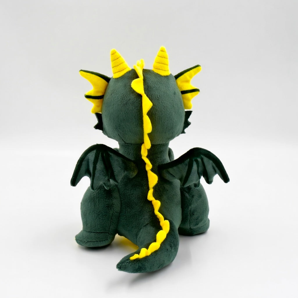 Smok Fortis – widok z tyłu. Pokazuje miękkie skrzydła i ogon zielono-żółtego pluszowego bohatera na odwagę.