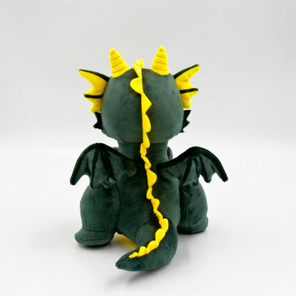 Smok Fortis – widok z tyłu. Pokazuje miękkie skrzydła i ogon zielono-żółtego pluszowego bohatera na odwagę.